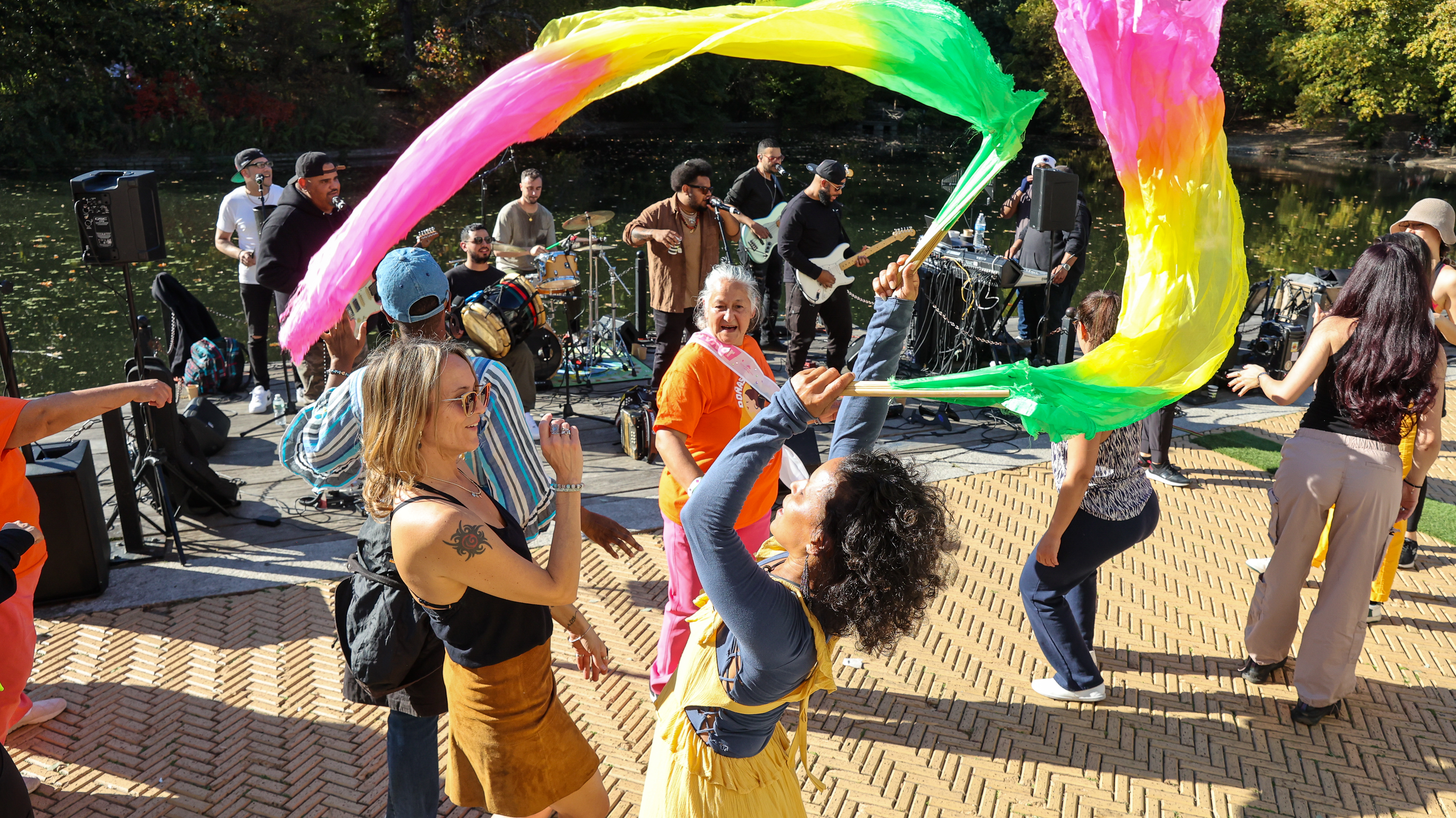 Community members join together to dance and sing with a live band at Brooklyn FAM's annual flagship festival by the lake at the Prospect Park Boathouse.