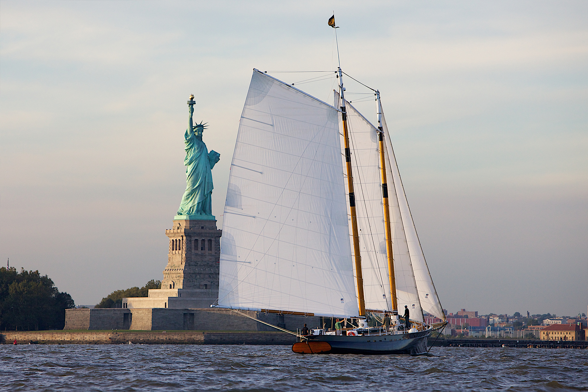 Schooner Sailing in NY Harbor passing the Statue of Liberty