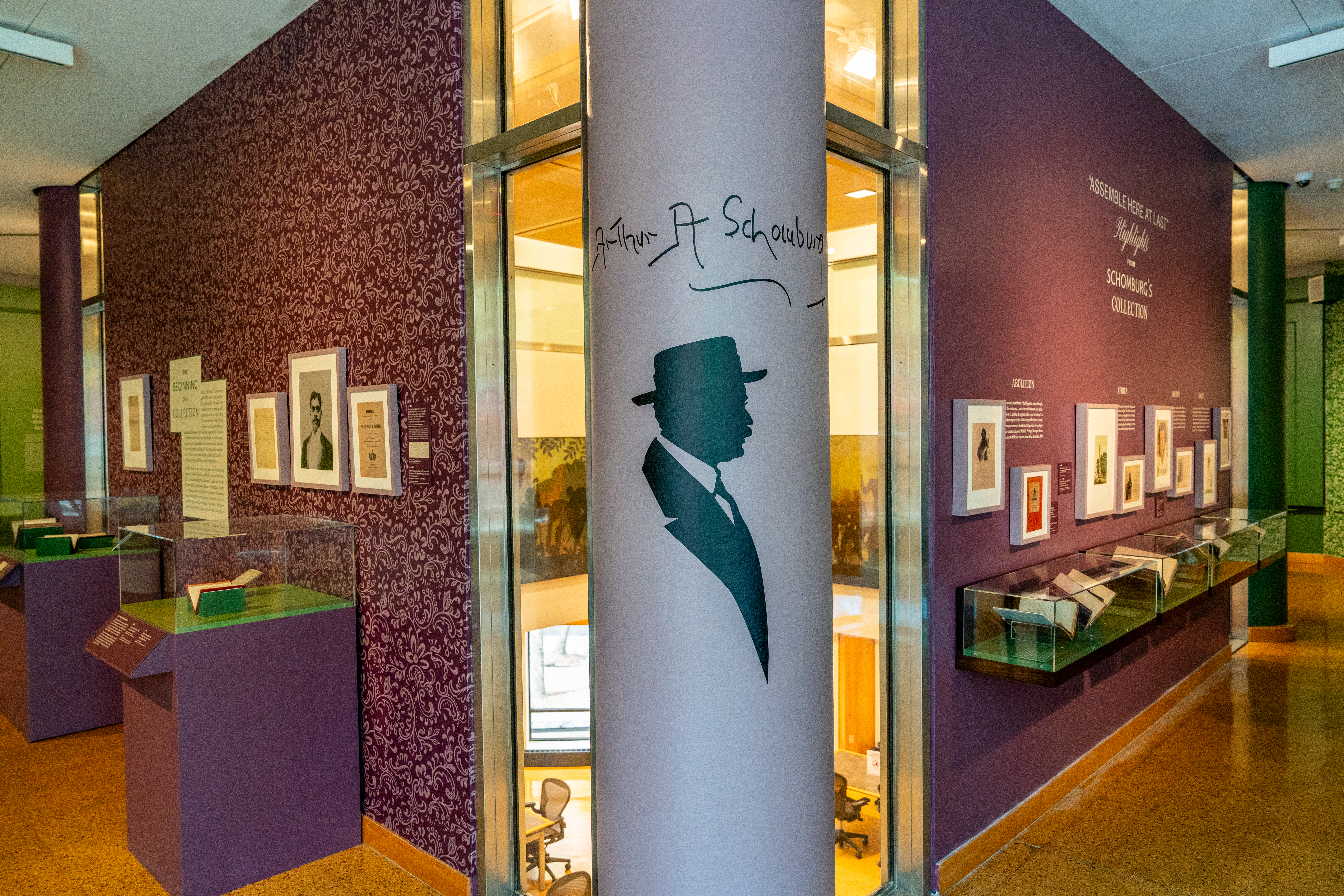 The corner of a gallery. In the center, there is a silhouette of a man with the signature of Arturo Schomburg. Gallery boxes line the sides of the walls.